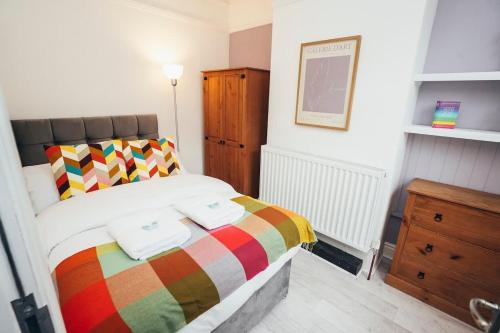 ein Schlafzimmer mit einem Bett mit zwei Handtüchern darauf in der Unterkunft 4BR Town House, Self Check In, Parking, By DerBnB in Derby