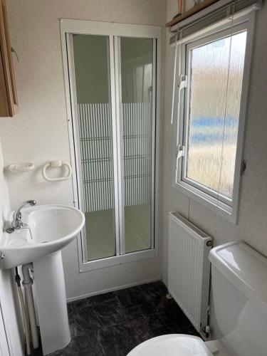 a bathroom with a toilet and a sink and a shower at 847 Promenade , Ingoldmells in Ingoldmells