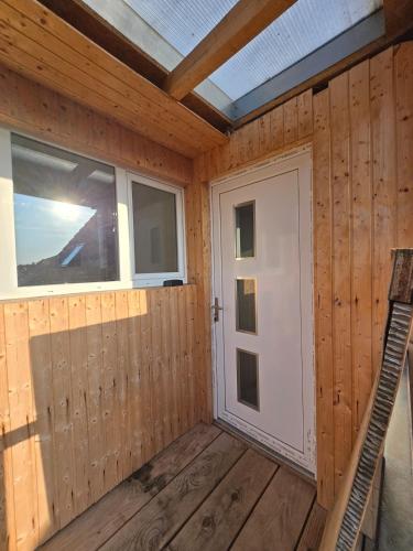 a wooden cabin with a door and a window at Les Combles du Moulin in Geudertheim