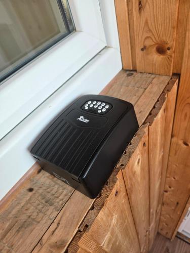 a black remote control sitting on top of a wooden table at Les Combles du Moulin in Geudertheim