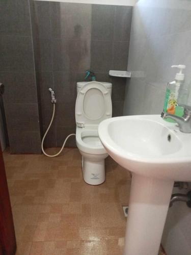 a bathroom with a toilet and a sink at Toto s House Junior Suite in Puerto Princesa City