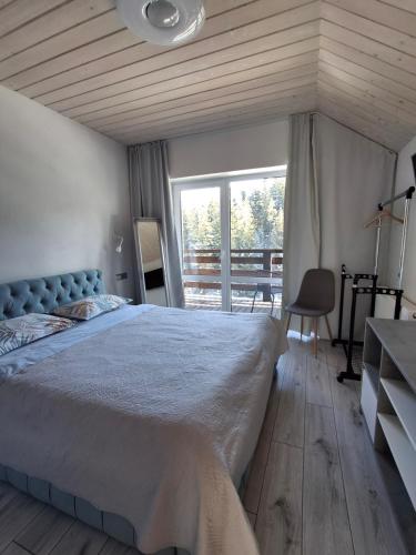 a bedroom with a large bed and a large window at Котедж у горах "Місце Сили" in Vorokhta