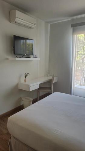 a bedroom with a bed and a desk and a tv at El Golf Hotel Boutique in Lima