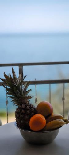 a plate with a pineapple and fruit on a table at Apartman None in Stomorska