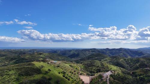 an aerial view of a valley with mountains and clouds at Portugals Infinity Eco Suite Resort in Tavira