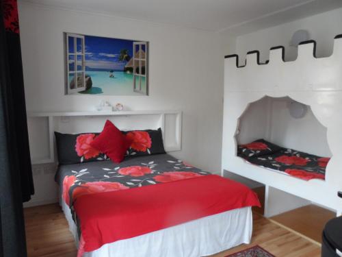a bedroom with a bed with a red comforter at Galway Guest House in Weymouth