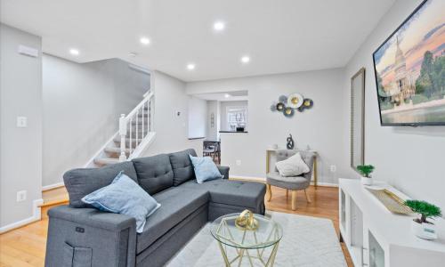 a living room with a couch and a staircase at Modern Luxury DC Free Parking in Arlington