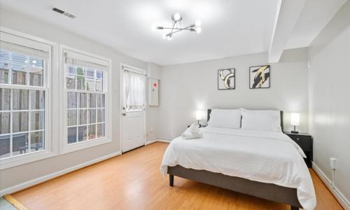 a white bedroom with a bed and two windows at Modern Luxury DC Free Parking in Arlington