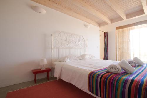 a bedroom with a white bed with towels on it at AMAZIGH VILLAS - 3 bedrooms, 2 bathrooms in Aljezur