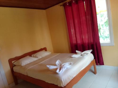 a bedroom with a bed with white bows on it at Poas Volcano & La Paz Waterfall Cabins in Montaña Azul