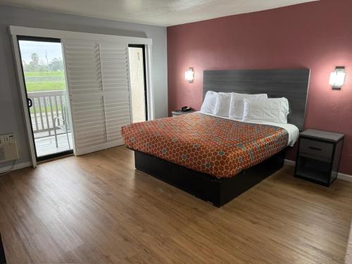 a hotel room with a bed and a balcony at Ocean Gate Inn in Santa Cruz