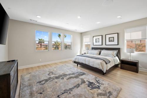 Un dormitorio con una cama y un televisor y ventanas. en Luxury Desert Escape Private Pool Putting Green Outdoor Oasis, en La Quinta