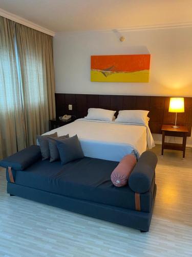 a bedroom with a large bed and a blue couch at Flat Fabuloso Executivo 3 in Sao Paulo