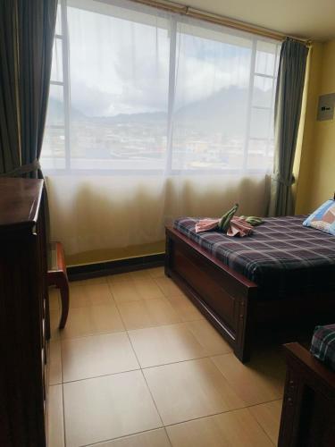 a bedroom with a bed and a large window at Dos Hemisferios in Quito