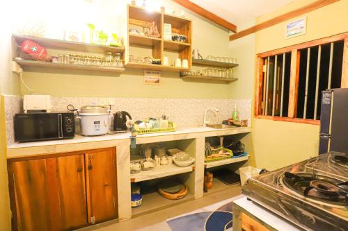 a kitchen with wooden cabinets and a counter top at Garnet Yala Beach in Kirinda