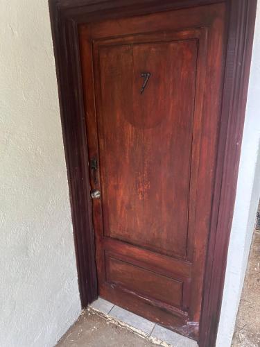 a wooden door with a handle in a room at Pura Vida Hostel in Tamarindo