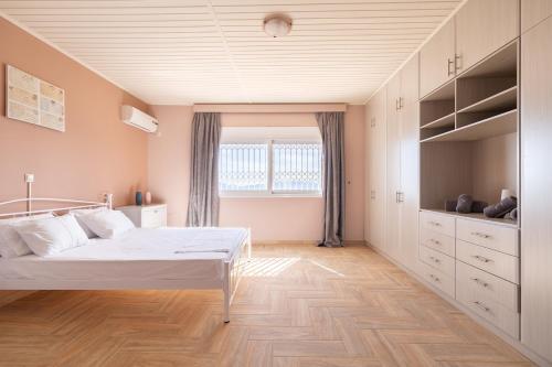 a bedroom with a white bed and a window at Spacious Villa With a Pool in Nea Peramos