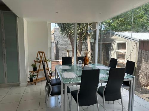a dining room with a glass table and chairs at Werribee 3 BR Holiday Home in Werribee