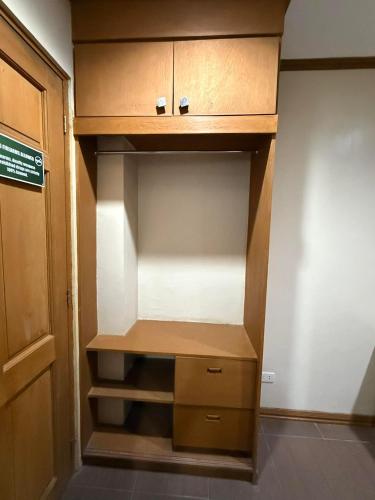 an empty closet with wooden shelves and a door at Subic Bay Baloy Long Beach Hotel in Olongapo