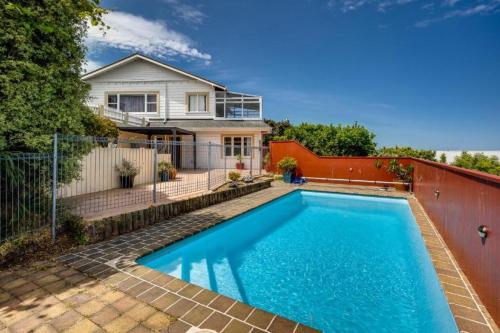 a swimming pool in front of a house at Napier Hilltop Stays - Views, Pool & Pet Friendly! in Napier