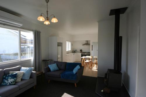 a living room with a couch and a dining room at Luxury Living Central College Estate Springvale in Whanganui