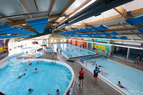 a large indoor swimming pool with many people in it at Luxury Living Central College Estate Springvale in Whanganui
