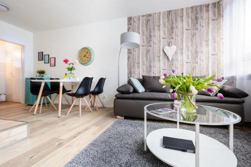ein Wohnzimmer mit einem schwarzen Sofa und einem Glastisch in der Unterkunft Deluxe Appartements am Münster in Freiburg im Breisgau