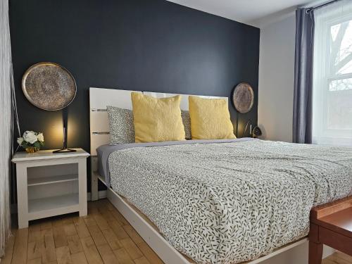 a bedroom with a bed with a black wall at Espace William by Hébergements DCL in Quebec City