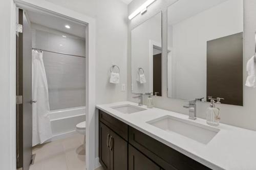 a white bathroom with two sinks and a toilet at The Modern Muse Art Home in Wheat Ridge