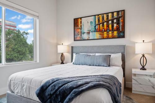 a bedroom with a large bed and two windows at The Modern Muse Art Home in Wheat Ridge