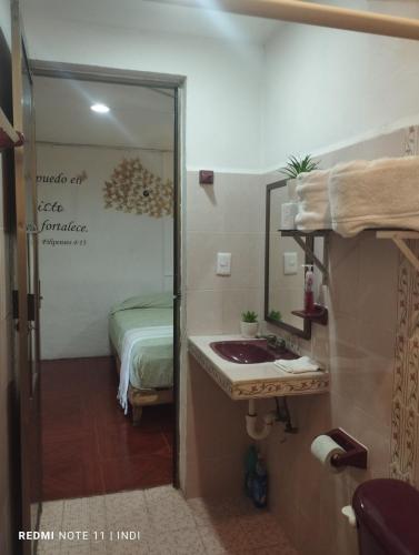 a bathroom with a sink and a bed in a room at casa brisa marina in Isla Mujeres