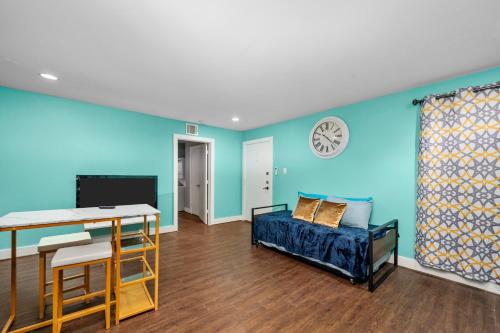 a room with blue walls and a bed and a couch at Sleek 1BR Retreat Near NRG and Med Center in Houston