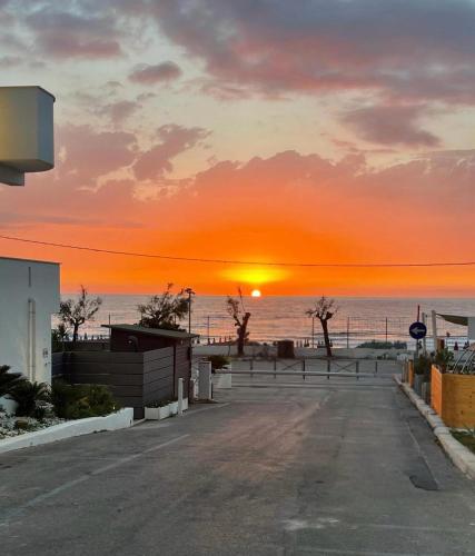 a sunset on the beach with the sun setting at DV holiday home in Isola delle Femmine