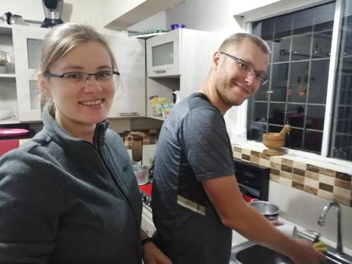 a man and a woman standing in a kitchen at Hostal las margaritas in Pasto