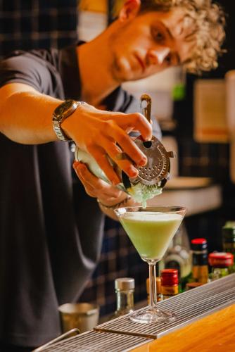 a man pouring a drink into a martini glass at Shoreline Hotel in Hobart
