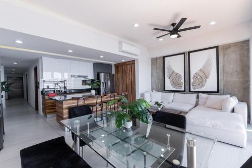 un salon avec un canapé blanc et une table en verre dans l'établissement Departamento con vista al mar1502-Torre Catania, à Mazatlán