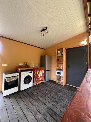 a kitchen with a washer and dryer in a room at Hava'i Lodge in Taputapuapea