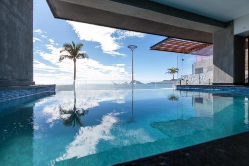 a pool of water with a palm tree in a building at Departamento con vista al mar1502-Torre Catania in Mazatlán
