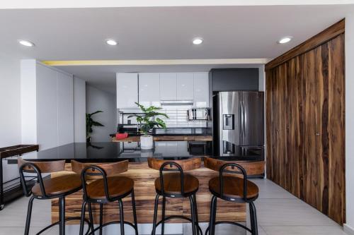 a kitchen with a table and chairs in a kitchen at Departamento con vista al mar1502-Torre Catania in Mazatlán