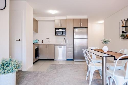 a kitchen and dining room with a table and chairs at 1 Bedroom Apartment In Braddon in Canberra