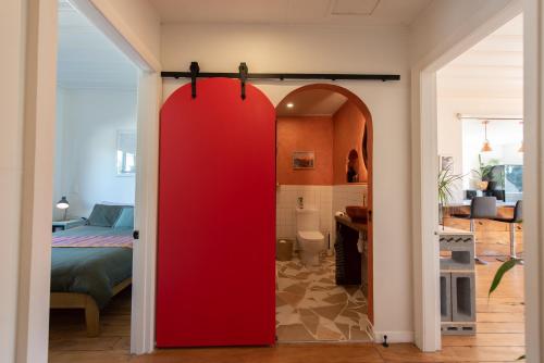 a red door in a room with a bedroom at Sunrays Stay - Stylish Retreat in New Plymouth