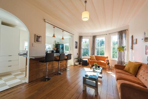 a living room with a couch and a table at Sunrays Stay - Stylish Retreat in New Plymouth
