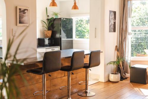 a kitchen with a wooden table and two chairs at Sunrays Stay - Stylish Retreat in New Plymouth