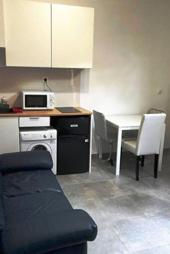 - une cuisine avec une table, un four micro-ondes, une table et des chaises dans l'établissement Beau 2-pieces rch très proche de Paris, à Gentilly