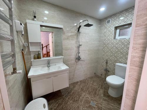 a bathroom with a white sink and a toilet at Gabala Deluxe 4-bedrooms Villa in Gabala