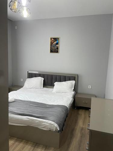 a bed in a bedroom with a picture on the wall at Gabala Deluxe 4-bedrooms Villa in Gabala