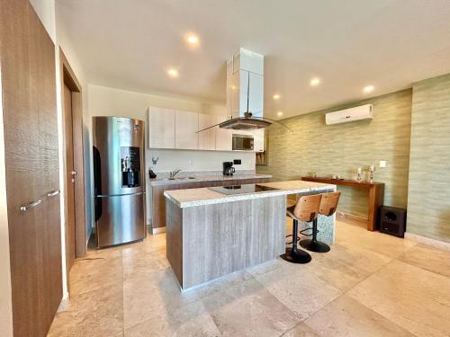 a kitchen with a refrigerator and a counter top at Vista a la ciudad sobre el malecón by G P S rentas in Mazatlán
