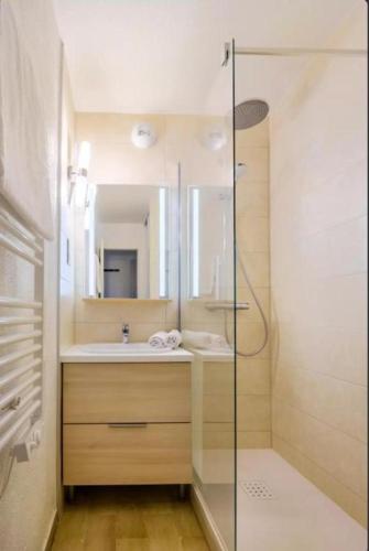 une salle de bain avec une douche en verre et un lavabo dans l'établissement Villa Livia - Citea - Groupe Pierre & Vacances Tourisme Piscine et mer à proximité - Résidence rénovée, à Cannes