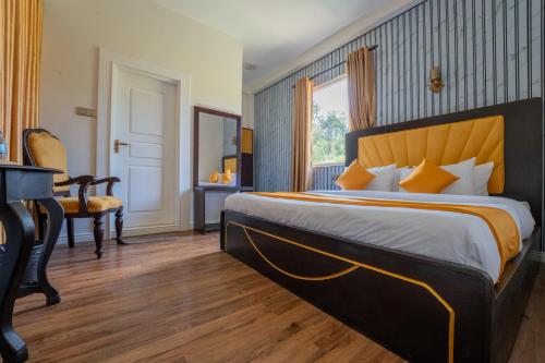 a hotel room with a large bed and a desk at London Eye Hotel Nuwaraeliya in Nuwara Eliya