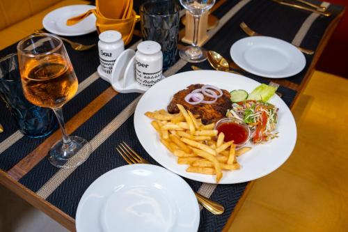 a table with a plate of food and french fries at London Eye Hotel Nuwaraeliya in Nuwara Eliya